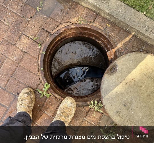 פתח ביוב פתוח עם נעליים מלוכלכות לידו